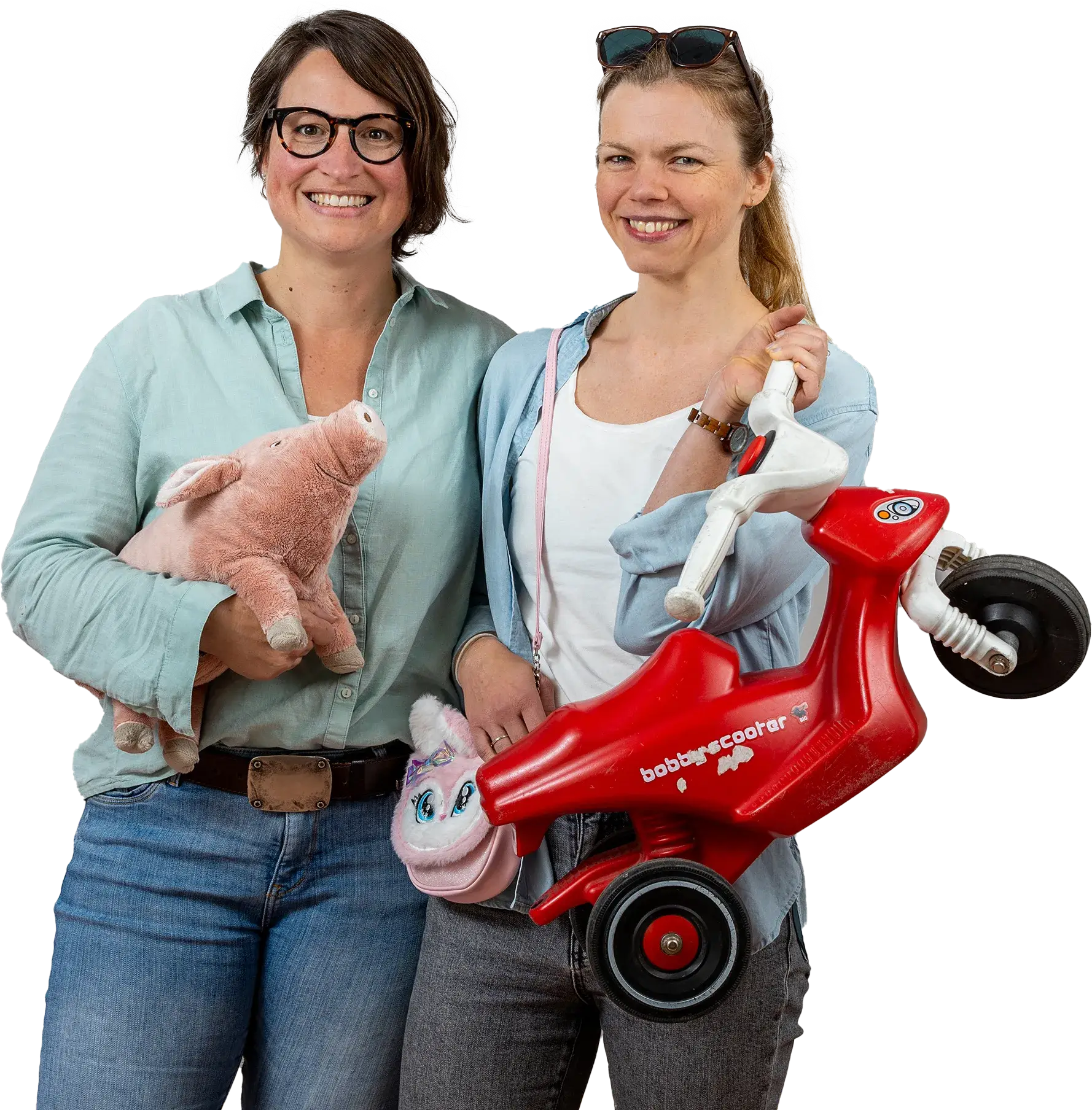 Zwei Personen lächeln in die Kamera und halten dabei einen Bobbyscooter und ein Plüschschwein
